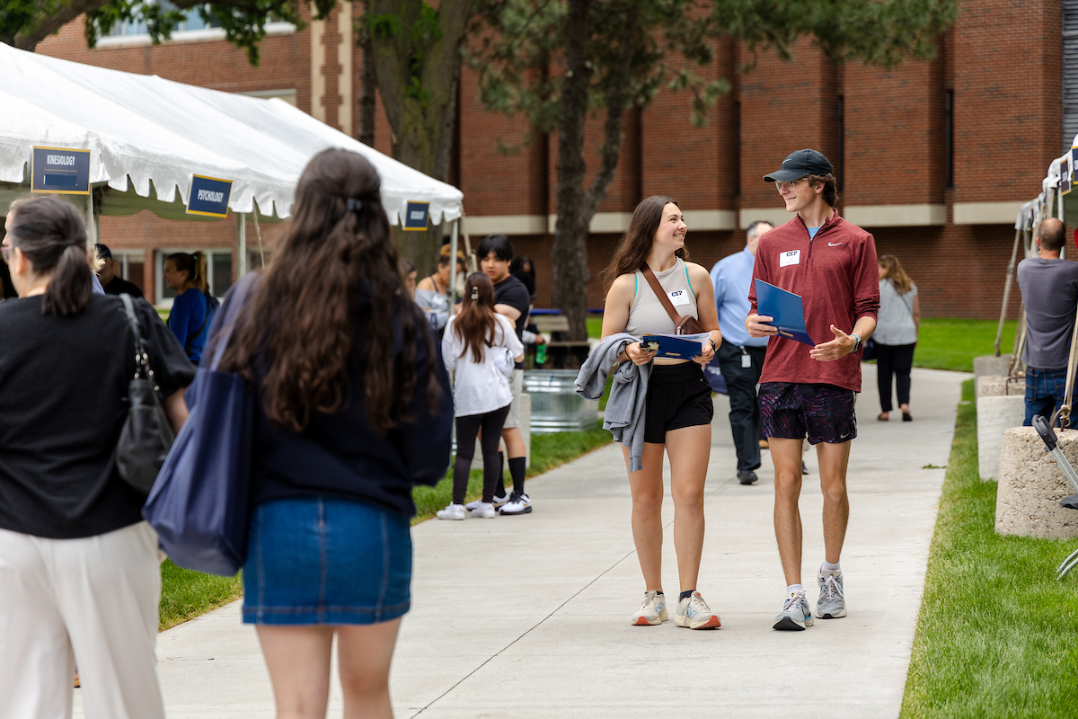 An image of two students walking on a sidewalk on the CSP campus during Admitted Student Day.
