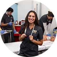 An image of a nursing student in scrubs posing with a stethoscope around her neck.
