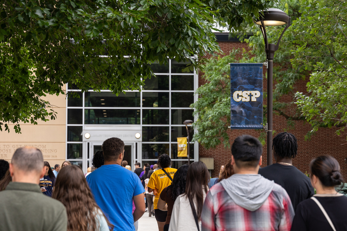 A group of visitors on the CSP campus walking toward the Library Technology Center.