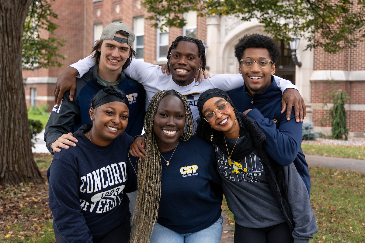 A group of six CSP students standing with their arms around each other and smiling.