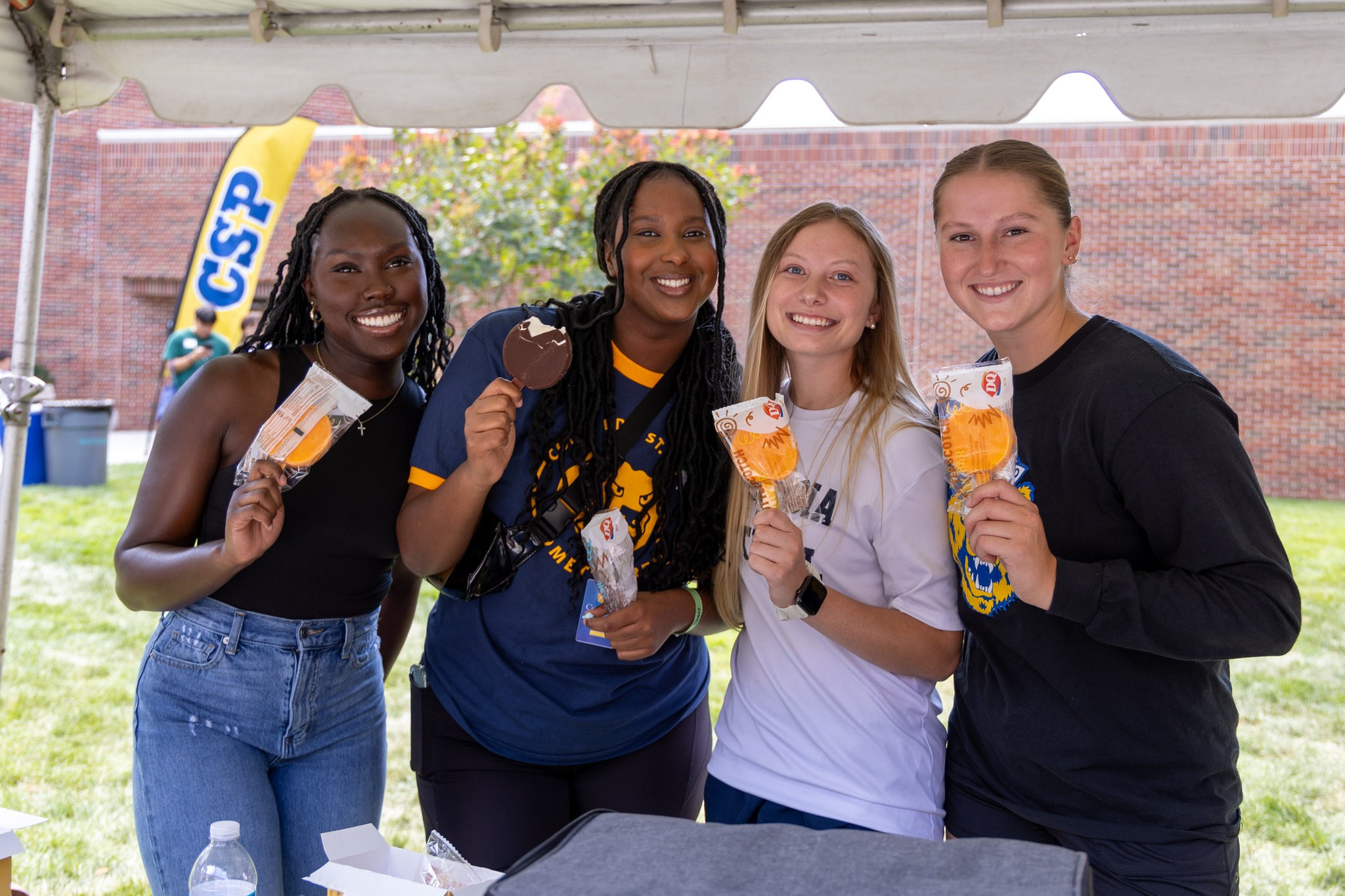 An image of four CSP students standing together smiling and holding up ice cream.